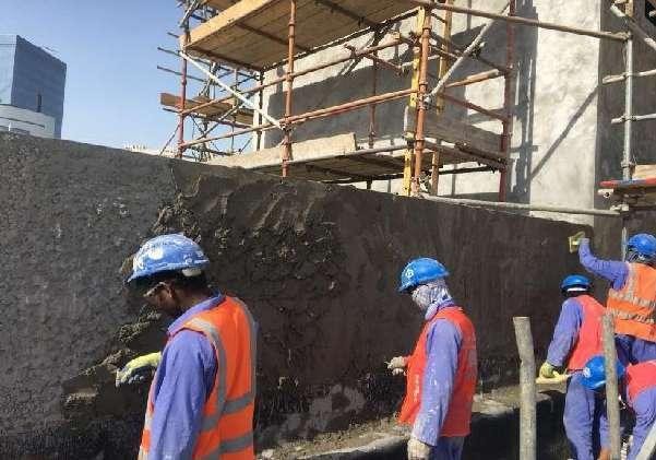 Site team applying cementitious fireproofing at Qatar Academy